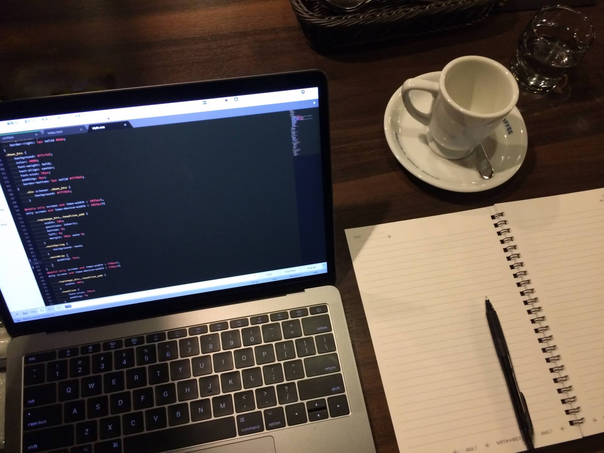 カフェでコーディングするノートパソコンとコーヒー