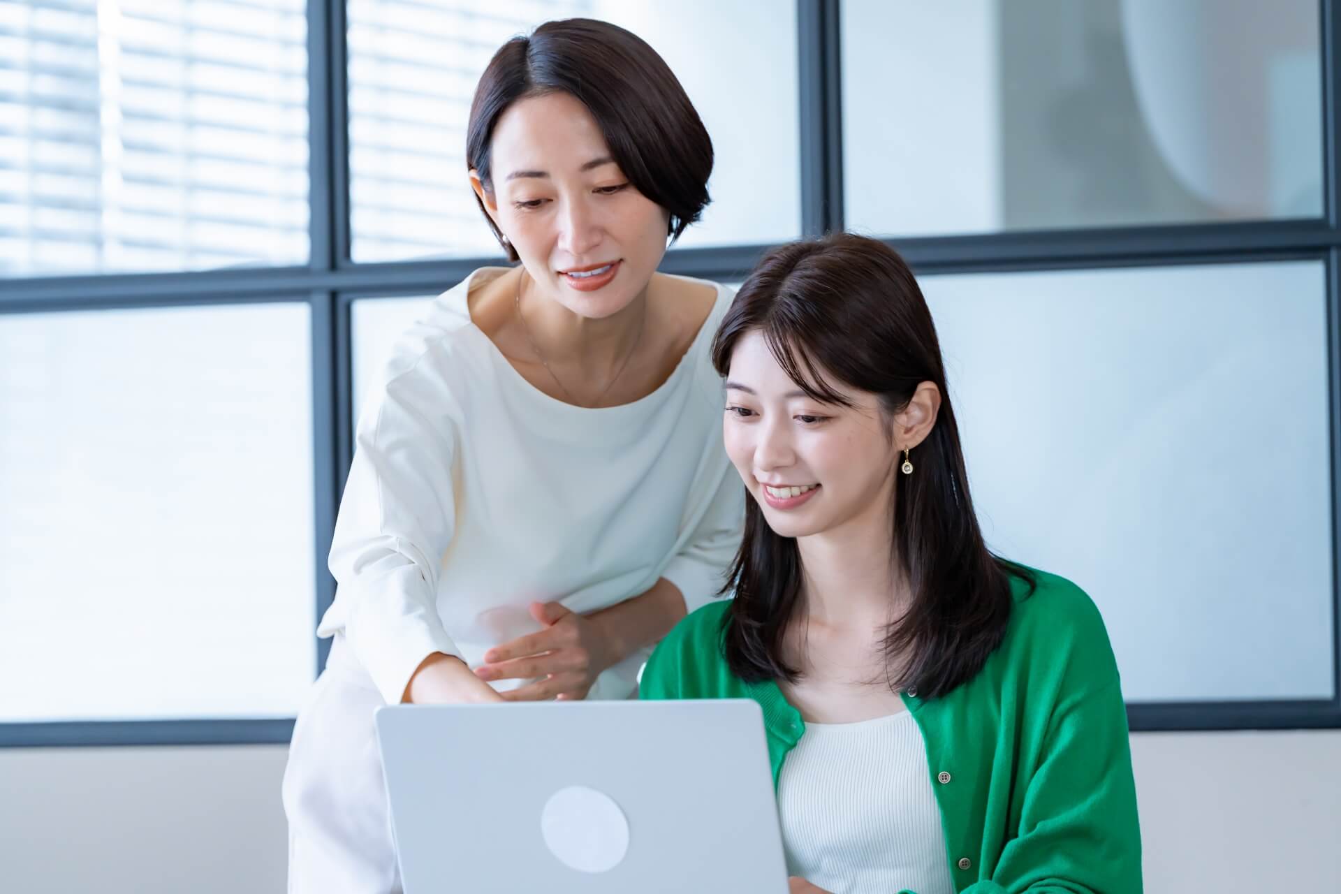 ノートパソコンを見る二人の女性