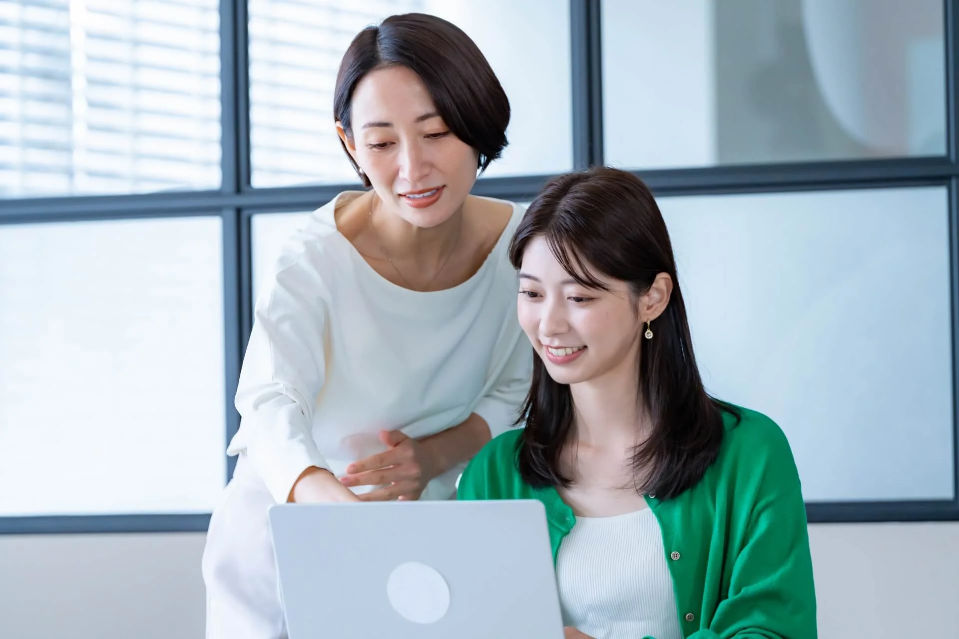 ノートパソコンを見る二人の女性